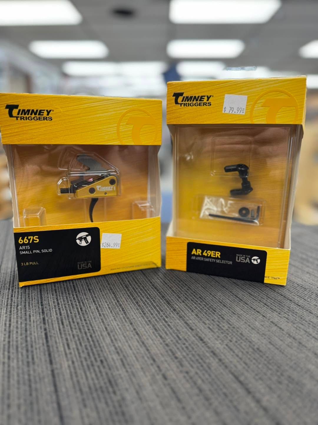 Two yellow Tomy toy boxes on carpet, one with a helicopter and one with a small black accessory