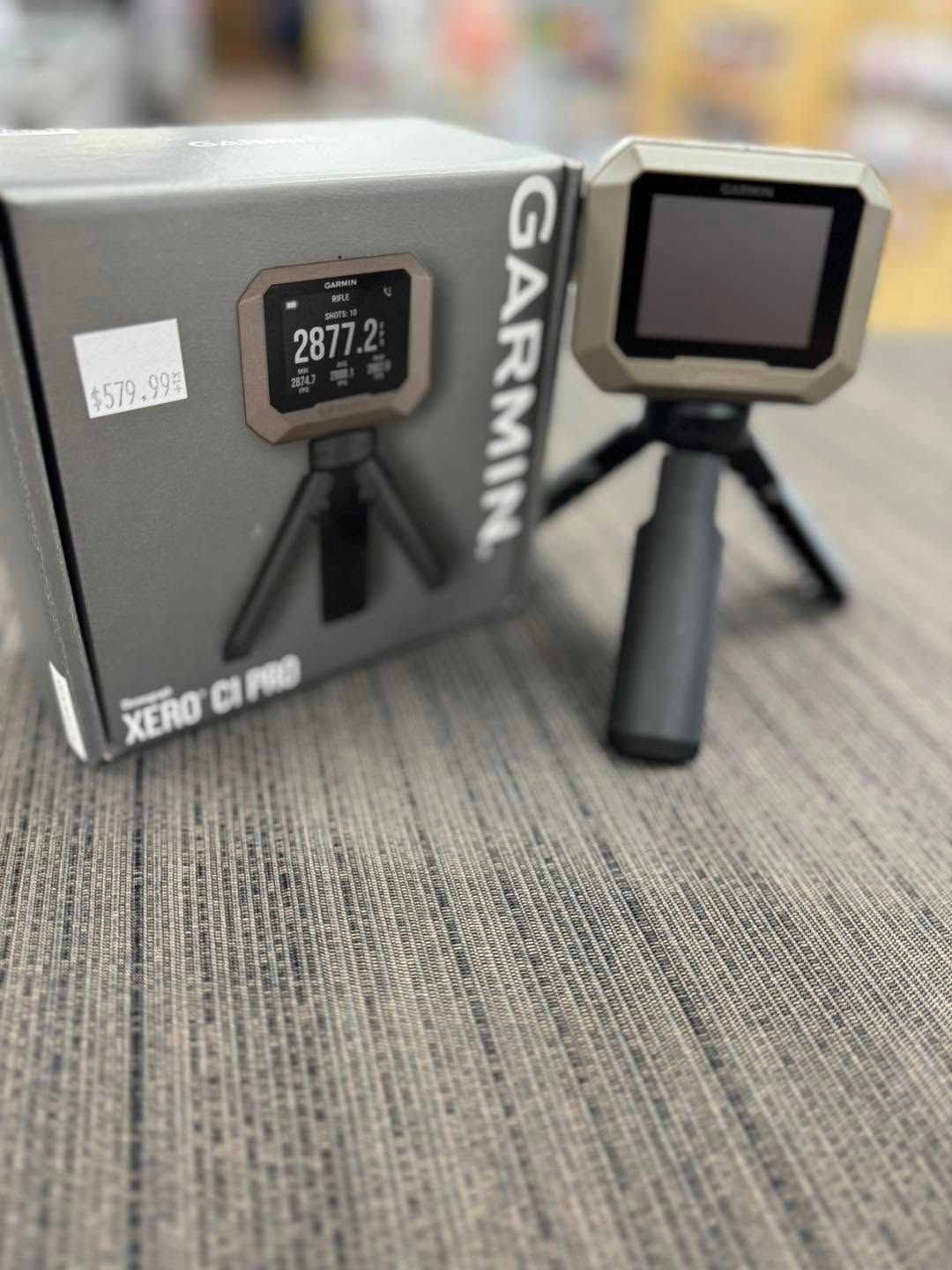 Garmin Xero C1 Pro box beside the device on a small tripod on a tabletop