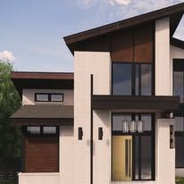 A modern house with a lot of windows and a roof.