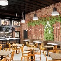 A restaurant with tables and chairs and a brick wall.