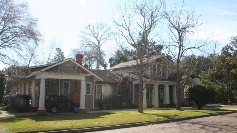 A couple of houses are sitting next to each other on a sunny day.