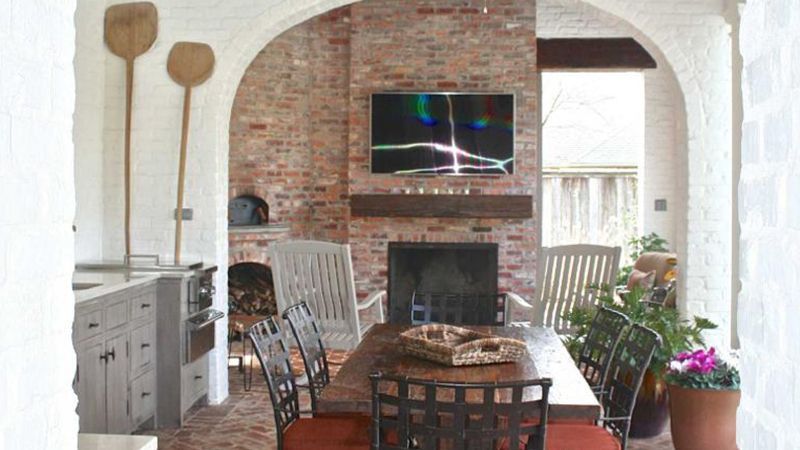 A dining room with a table and chairs and a fireplace.