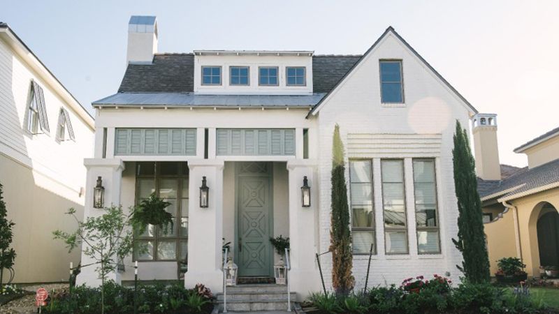The front of a white house with a blue door