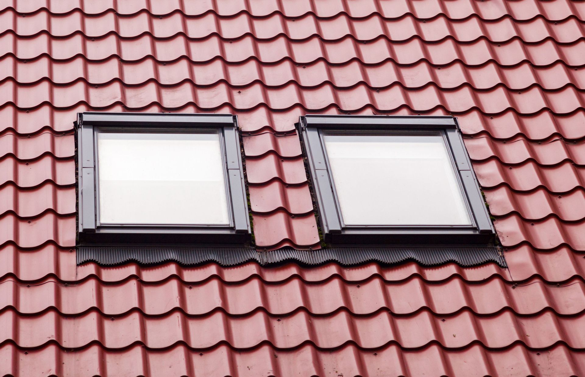 Two skylights on a red tiled roof.