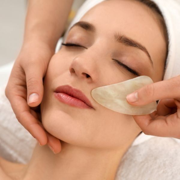 A woman is getting a massage on her face