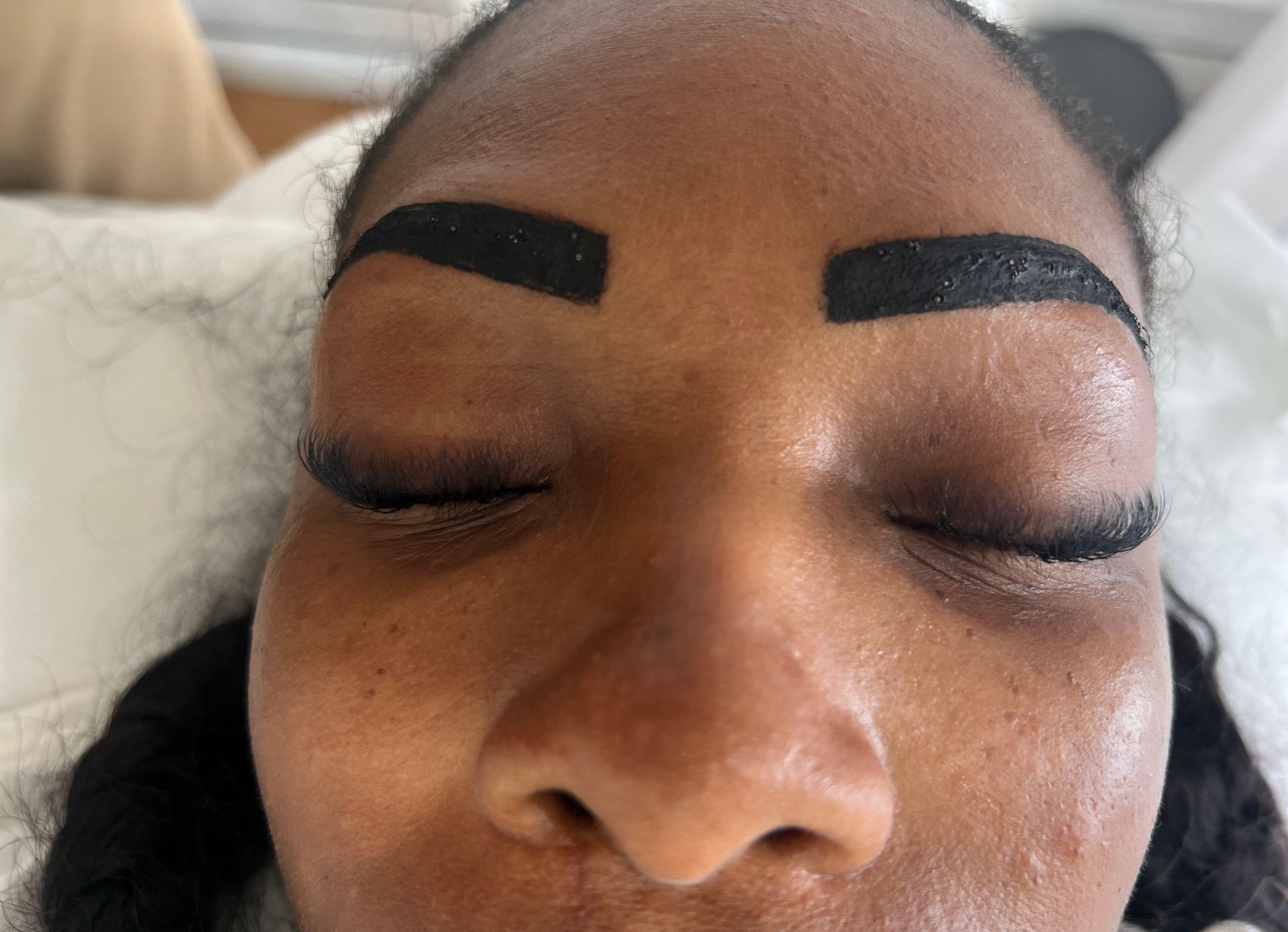A close up of a woman 's face with black eyebrows.