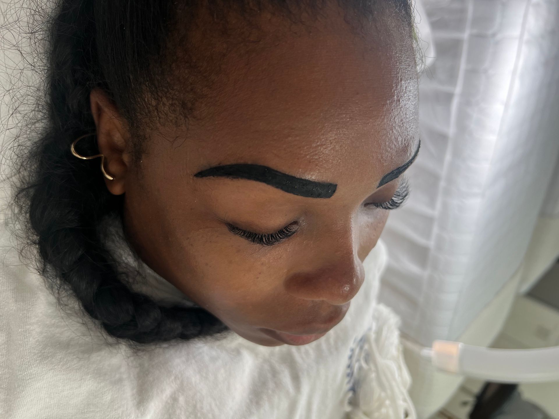 A close up of a woman 's face with her eyes closed