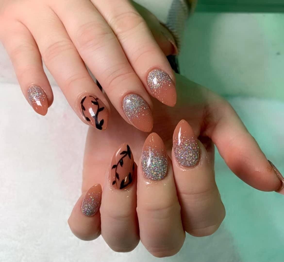 A close up of a woman 's nails with a design on them