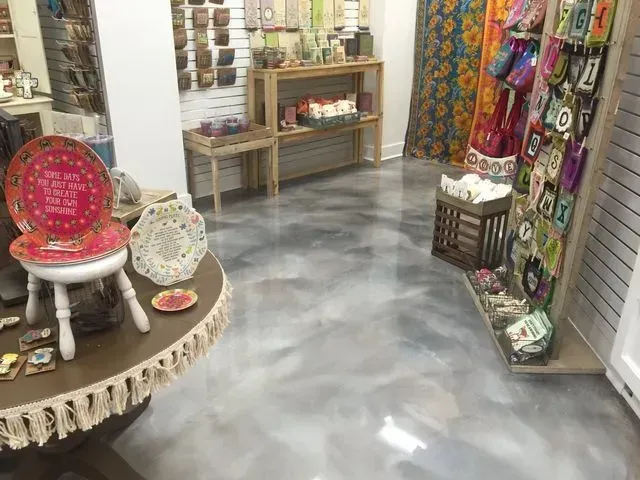 Retail store interior with silver epoxy floor, shelves of items, and decorative displays.