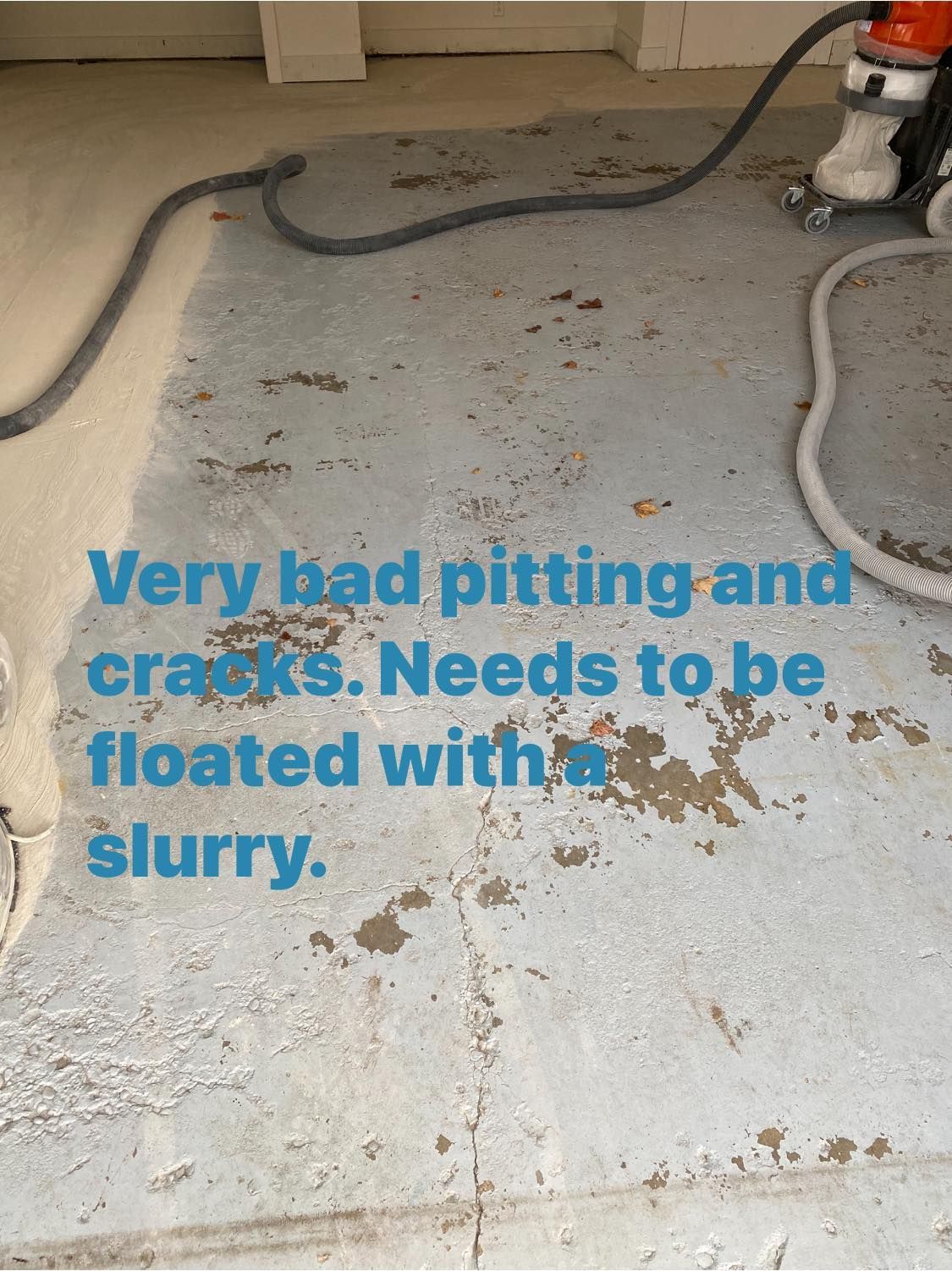 Cracked and pitted concrete floor with slurry needed for repair. Gray with water stains and debris.