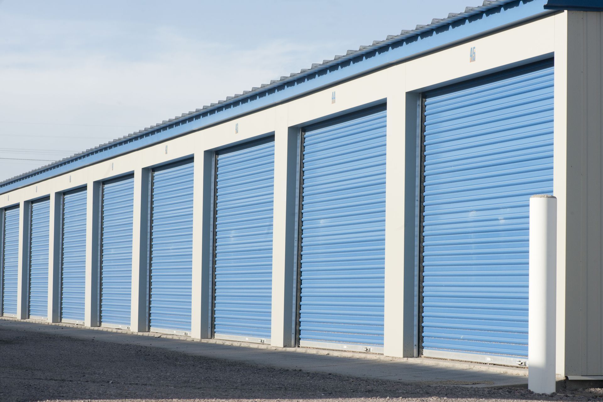 Row of blue storage unit doors in a white-framed building.