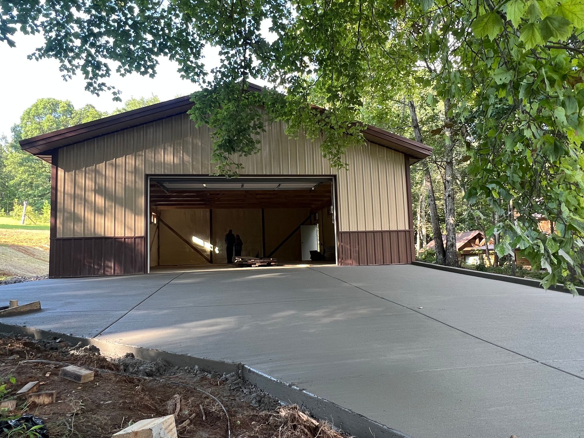 A large garage with a concrete driveway in front of it.