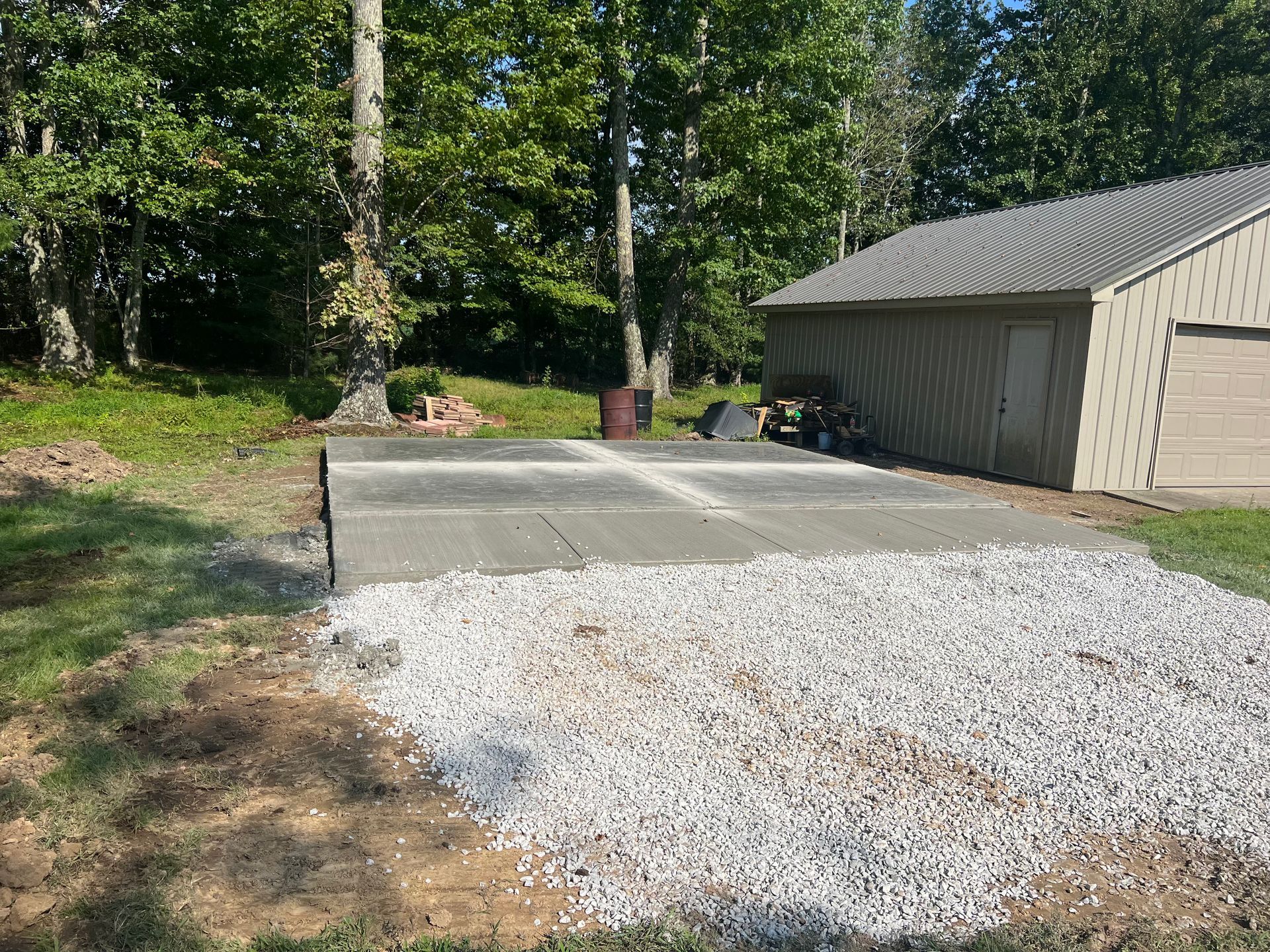 A concrete driveway is being built in front of a garage.