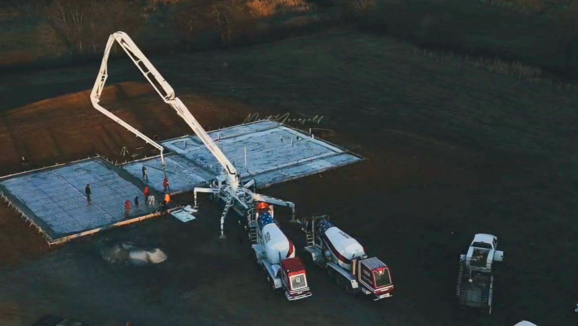 An aerial view of a construction site with trucks and a crane