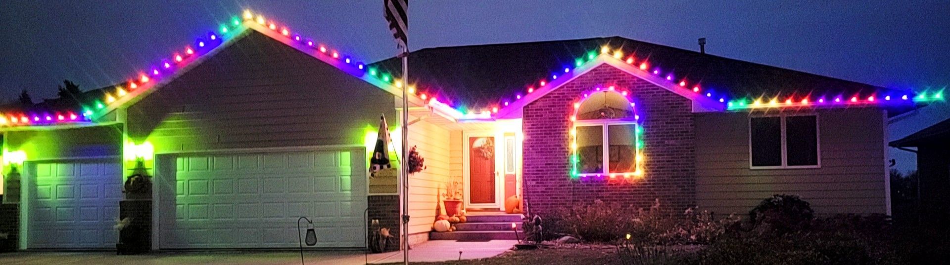 A house with christmas lights on it at night.