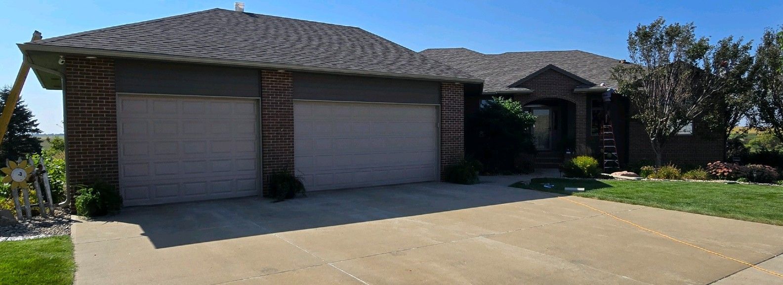 A house with two garage doors and a driveway in front of it.