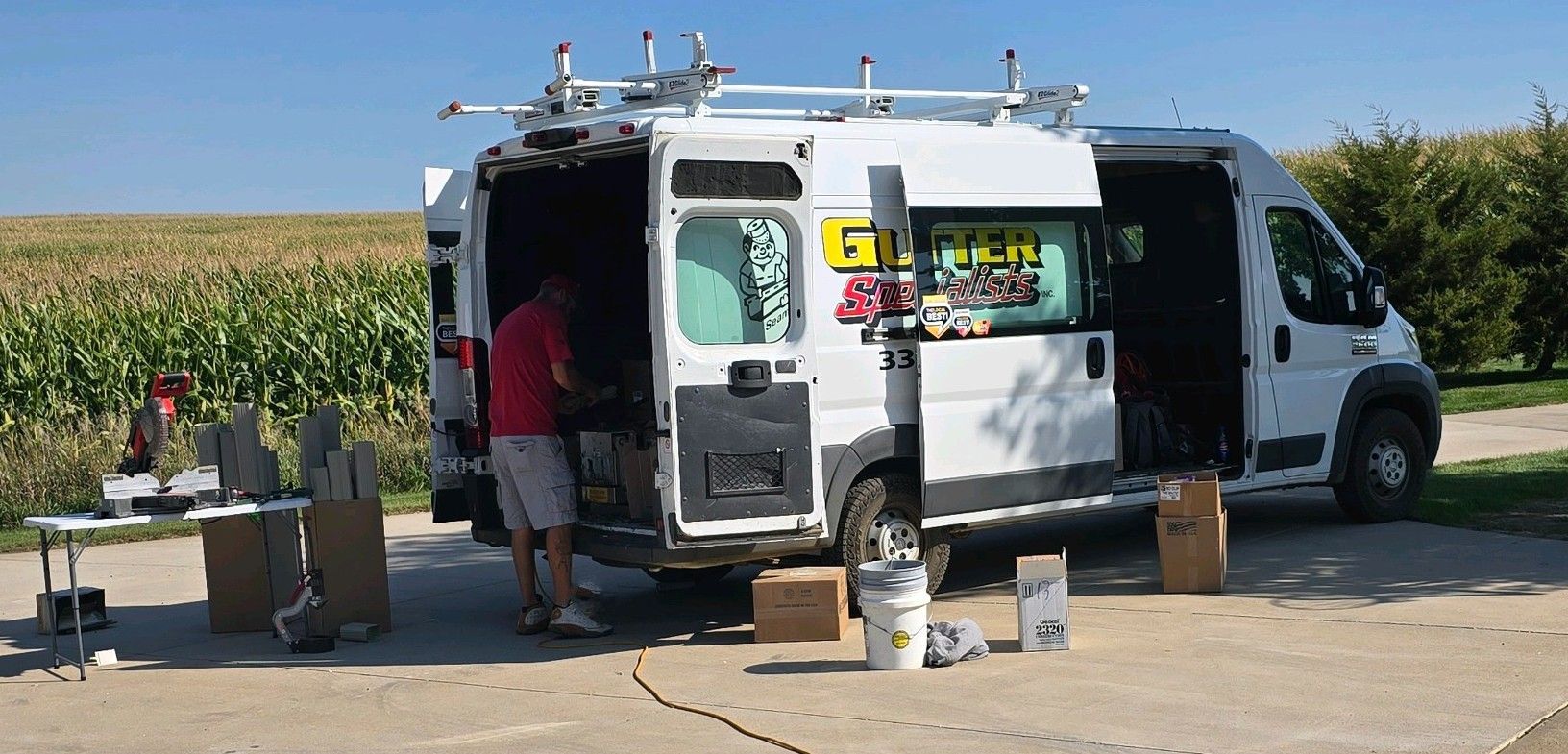 A white van is parked in a parking lot with the door open.