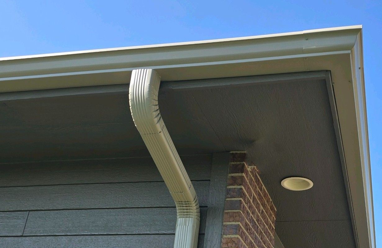 A gutter on the side of a house with a blue sky in the background