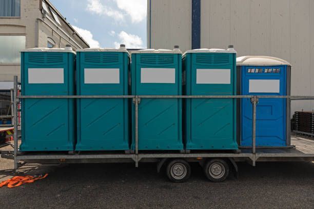 A trailer filled with portable toilets is parked in front of a building.