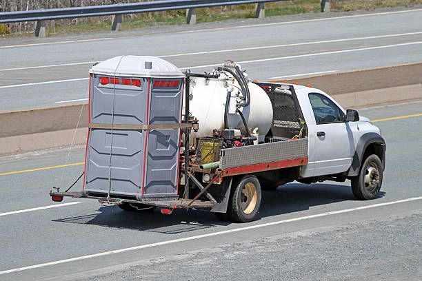 A truck with a portable toilet on the back of it