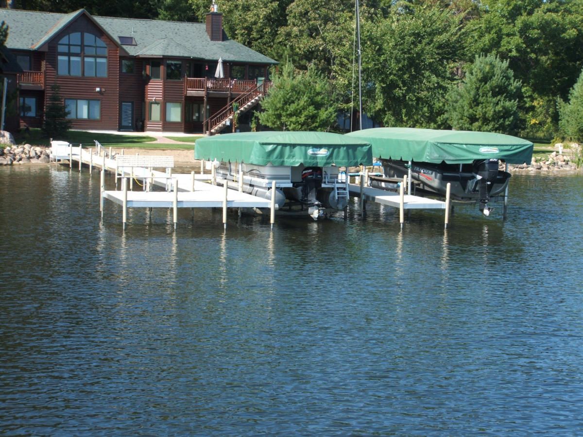 A boat is docked at a dock with a house in the background