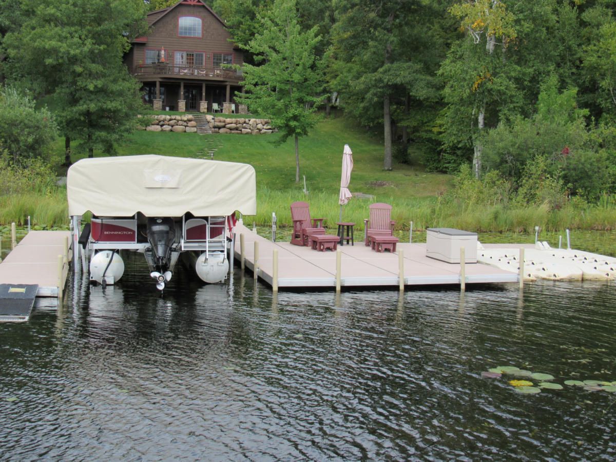 A boat is docked at a dock with a house in the background