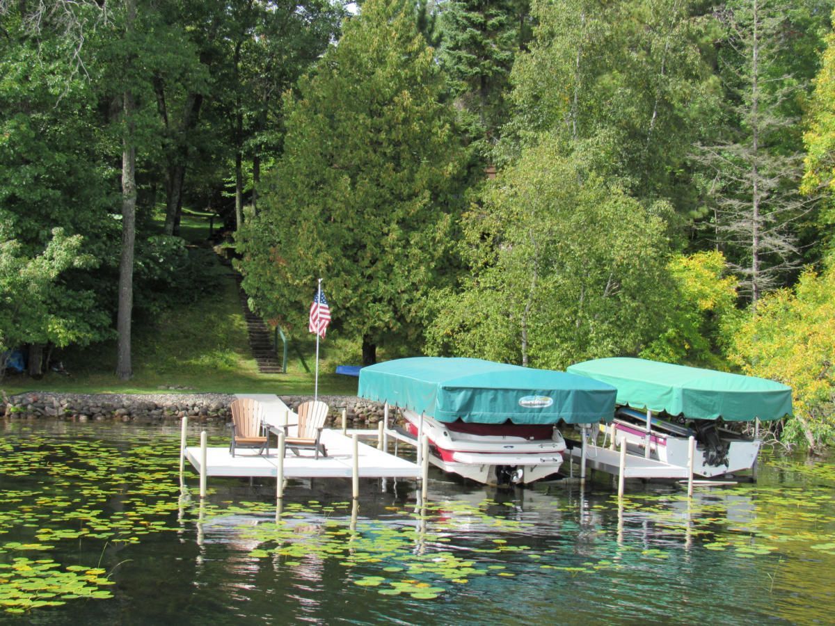 Two boats are docked at a dock on a lake