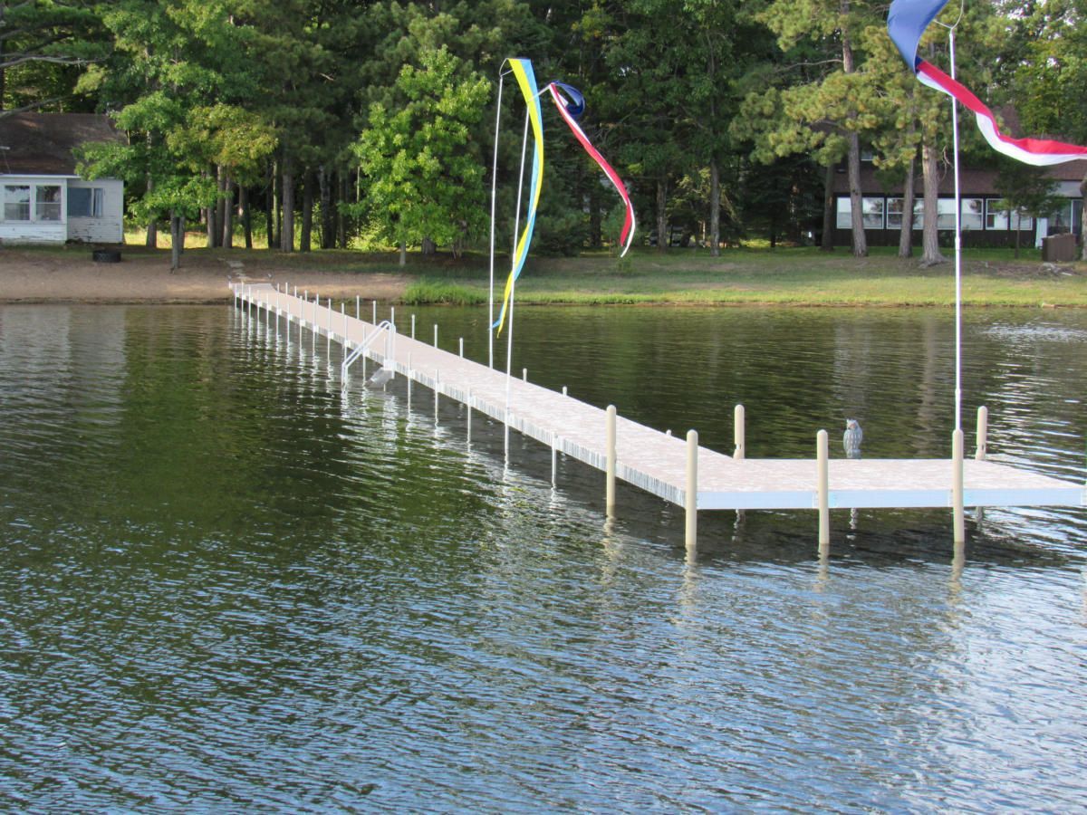 A dock on a lake with a house in the background