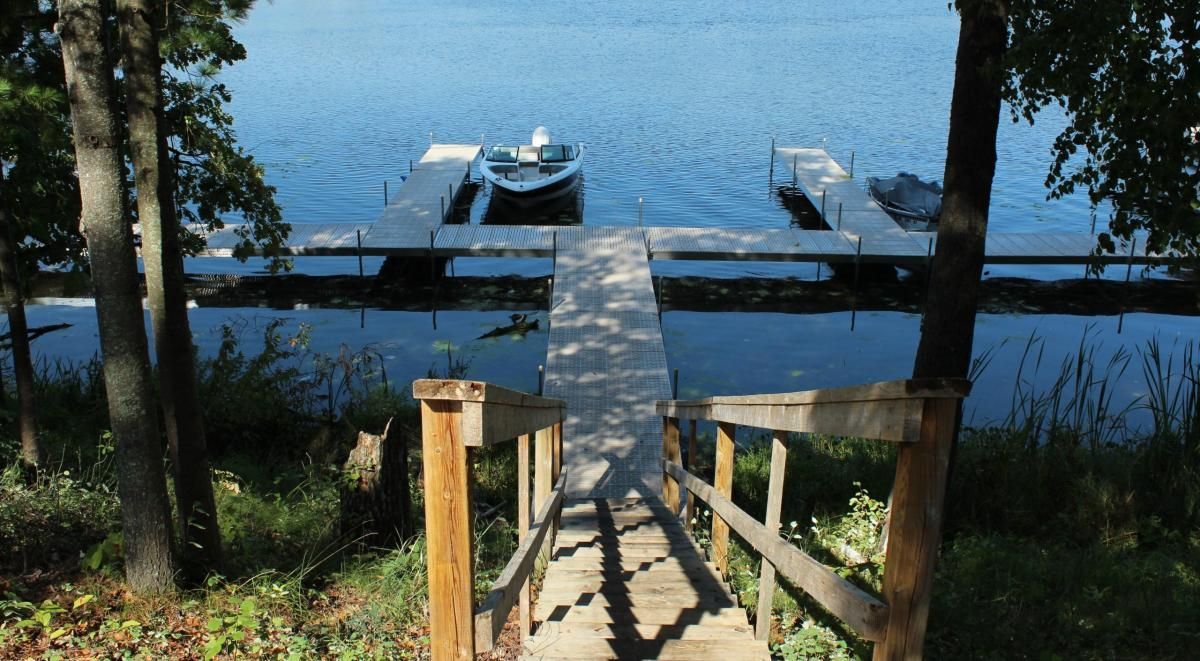 A wooden dock leads to a boat in the water