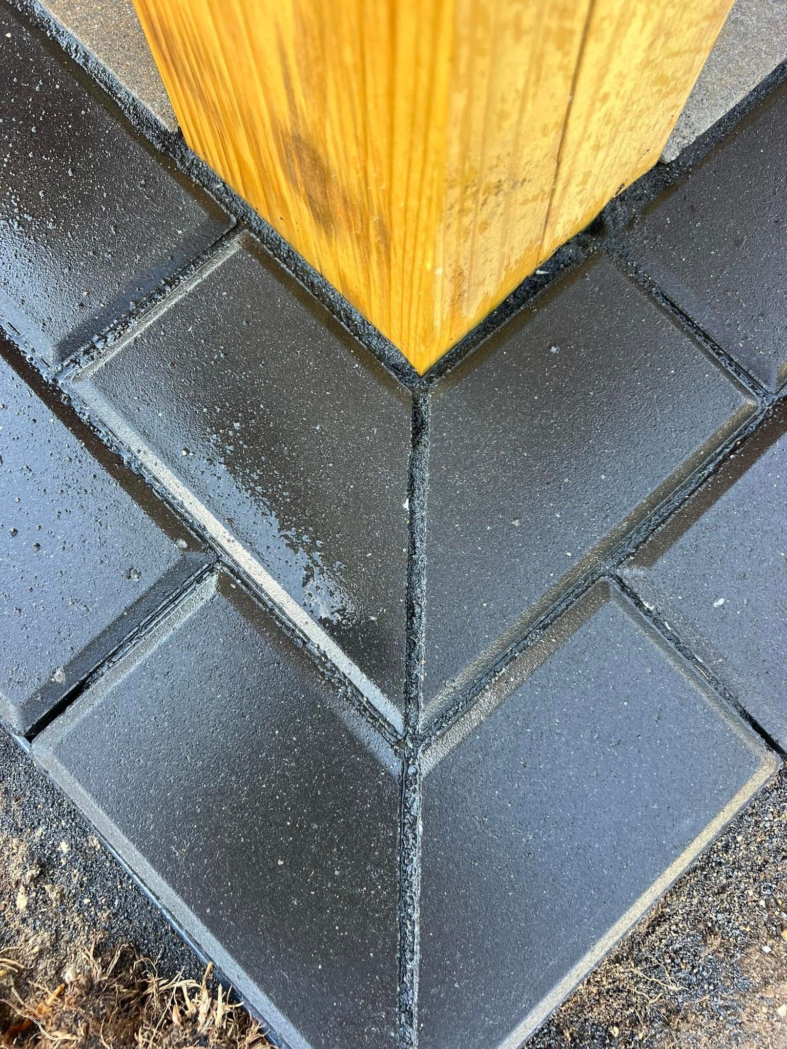 A close up of a wooden post on a brick walkway.