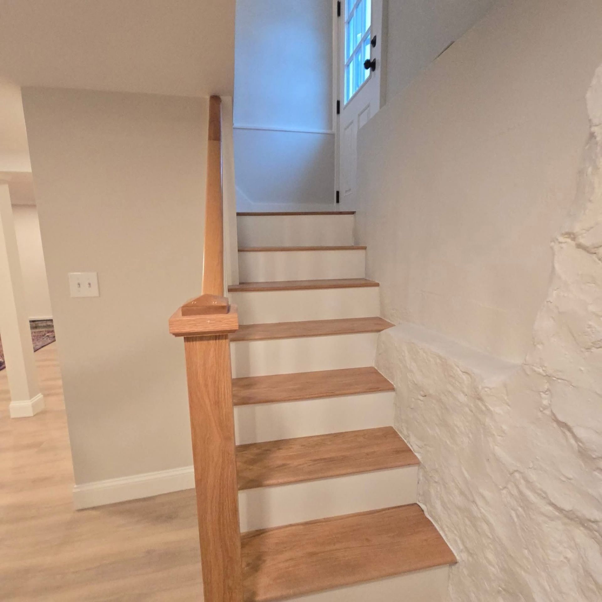 A set of wooden stairs leading up to the second floor of a house.