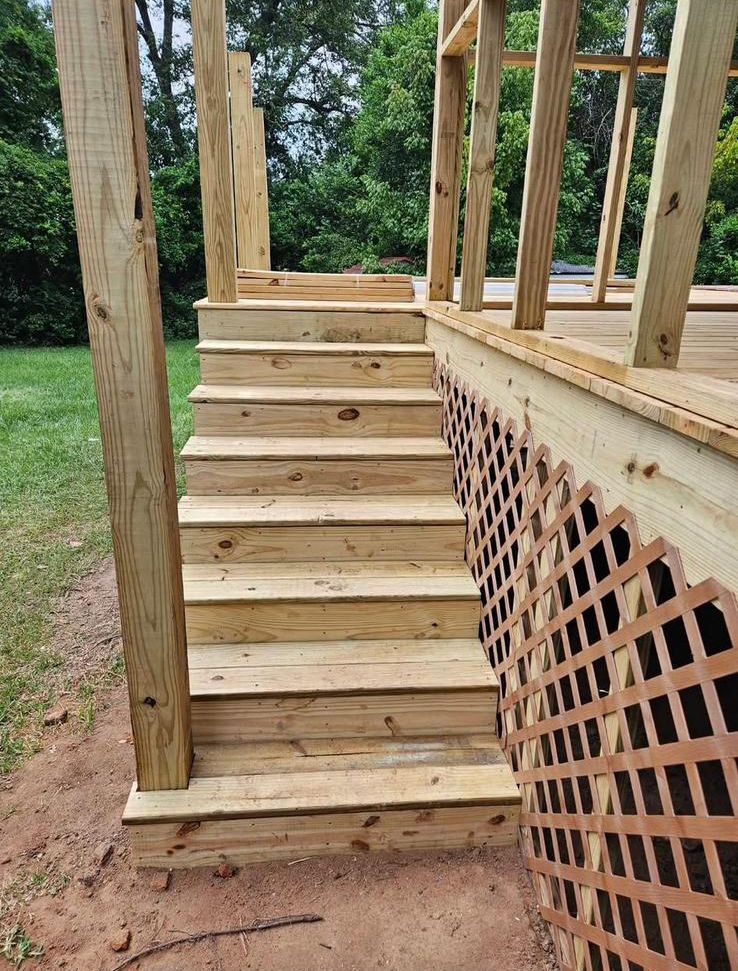 A set of wooden stairs leading up to a deck under construction.