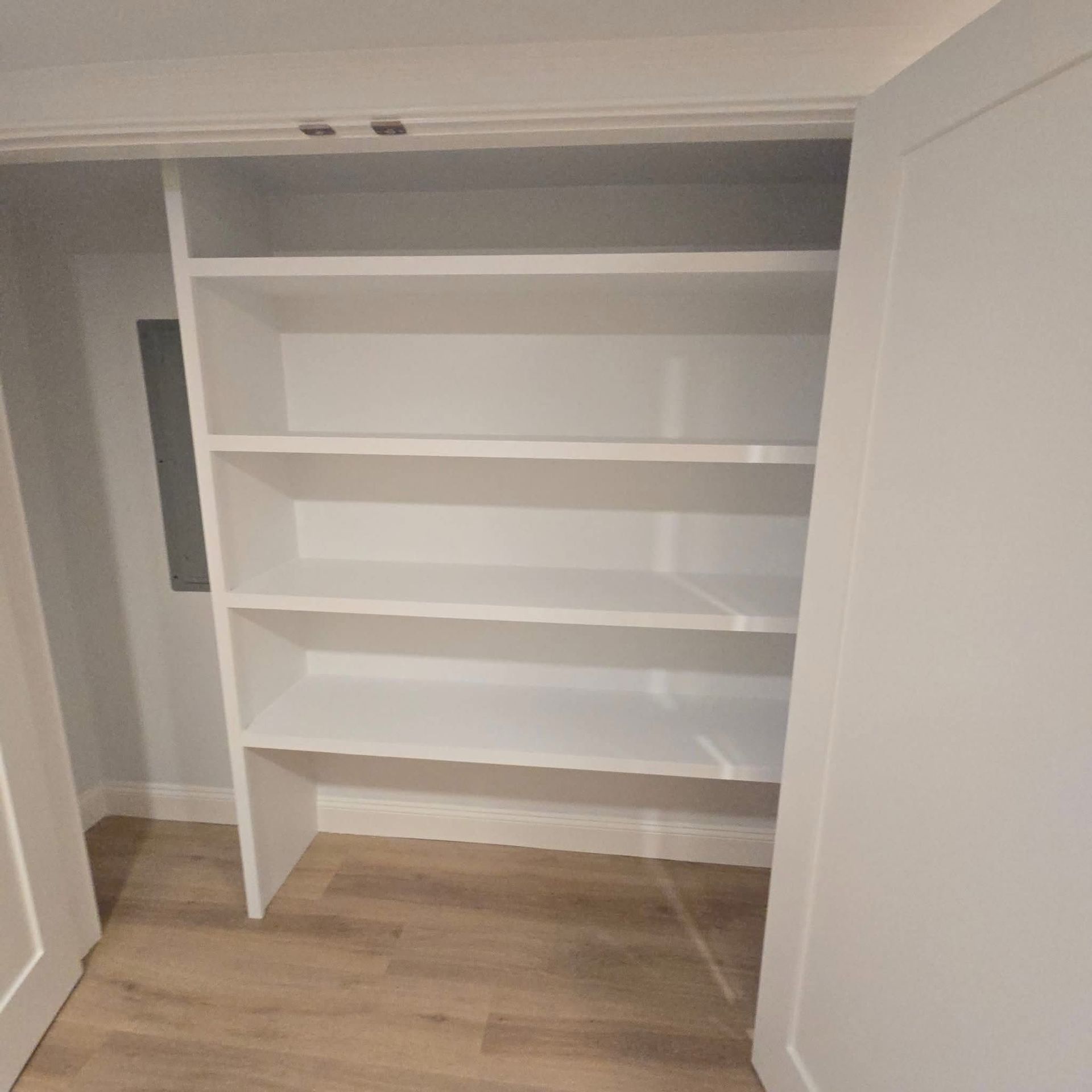 A closet with shelves and a door that is open