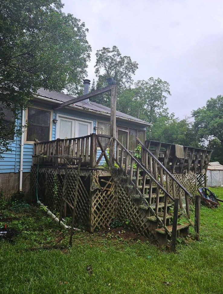 A house with a deck and stairs in the backyard.