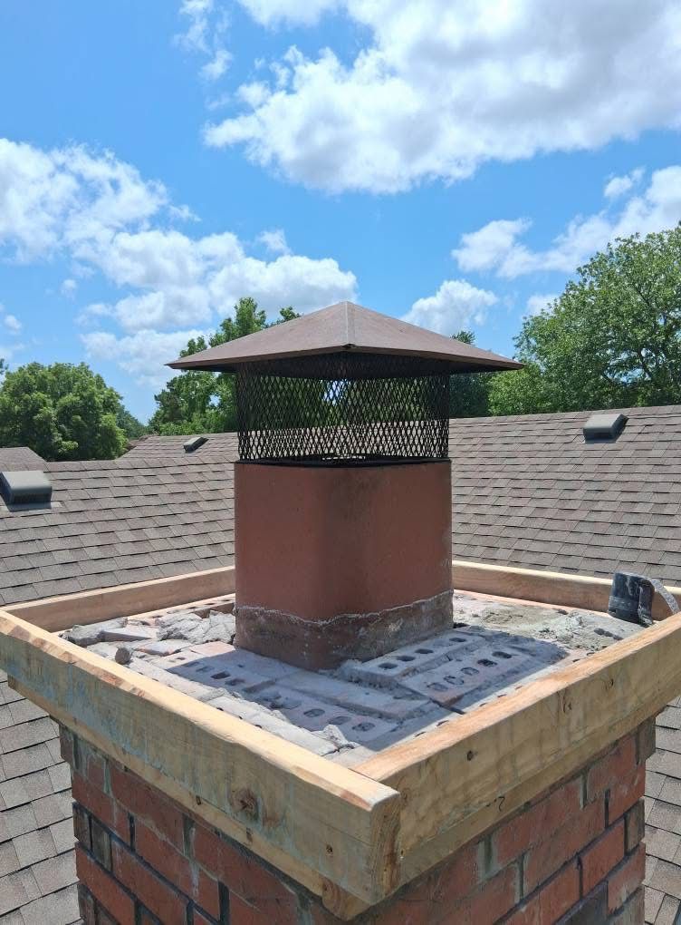 A brick chimney is sitting on top of a wooden roof.