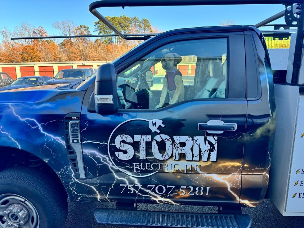 Storm roofing pickup truck with lightning graphics and company phone number parked outdoors