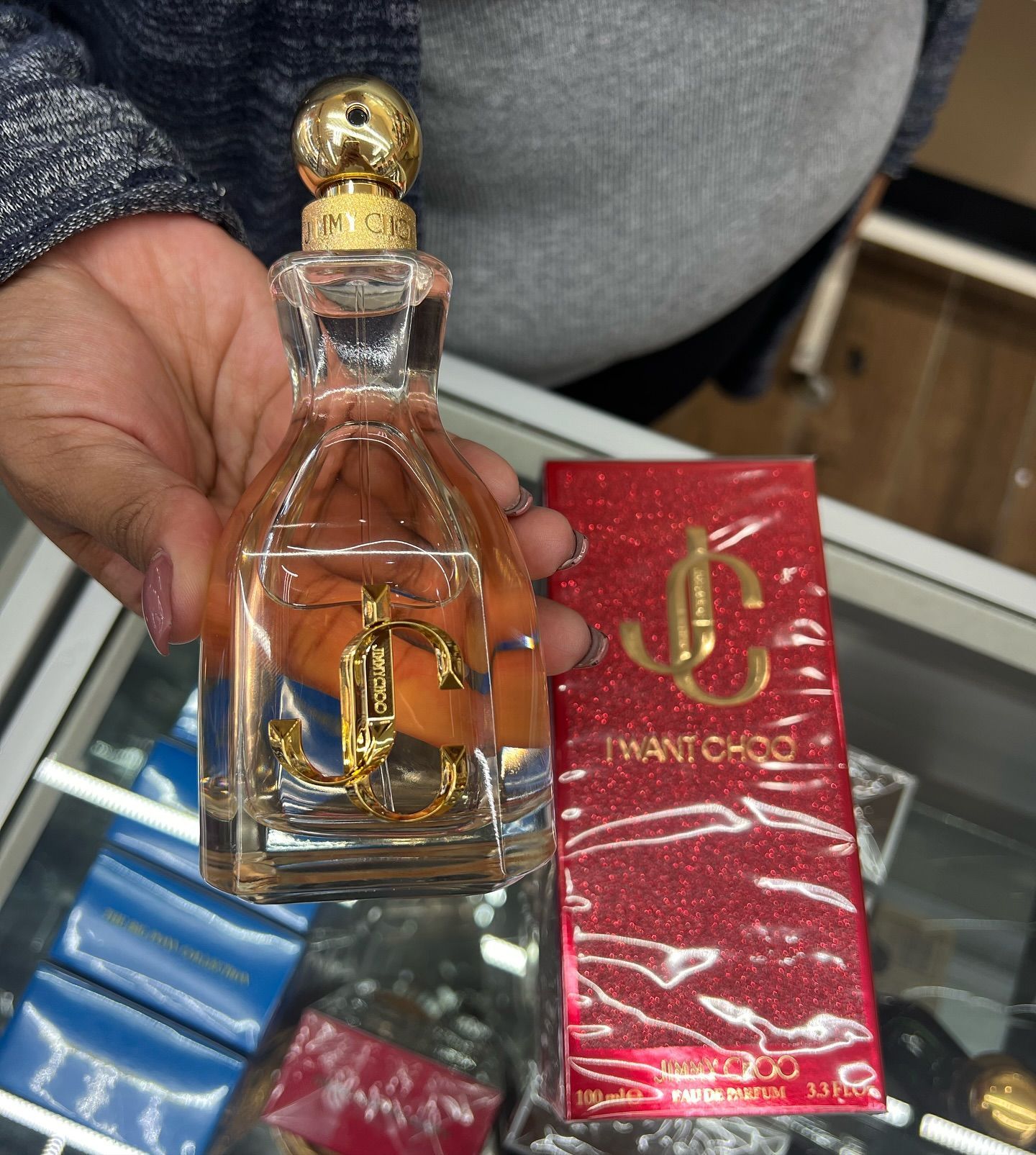 A person is holding a bottle of jimmy choo perfume