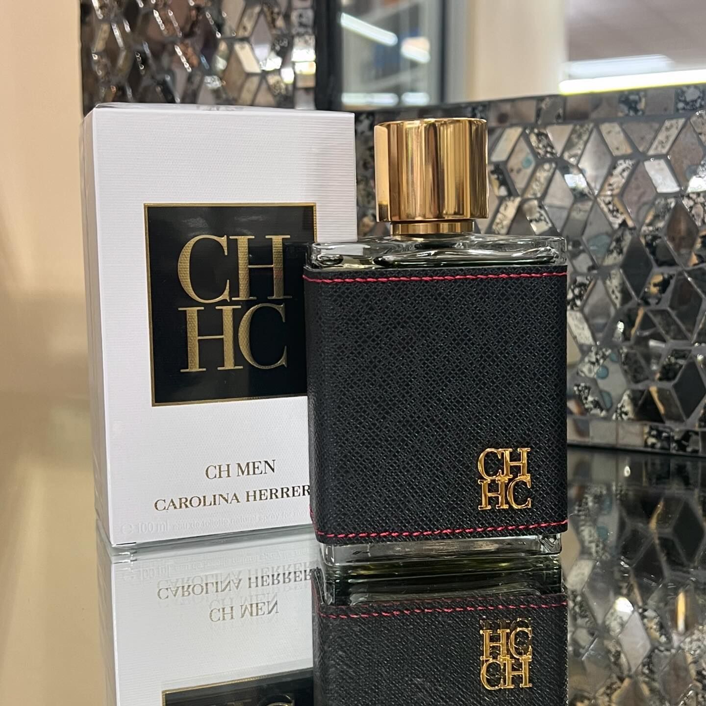 A bottle of ch hc perfume next to its box