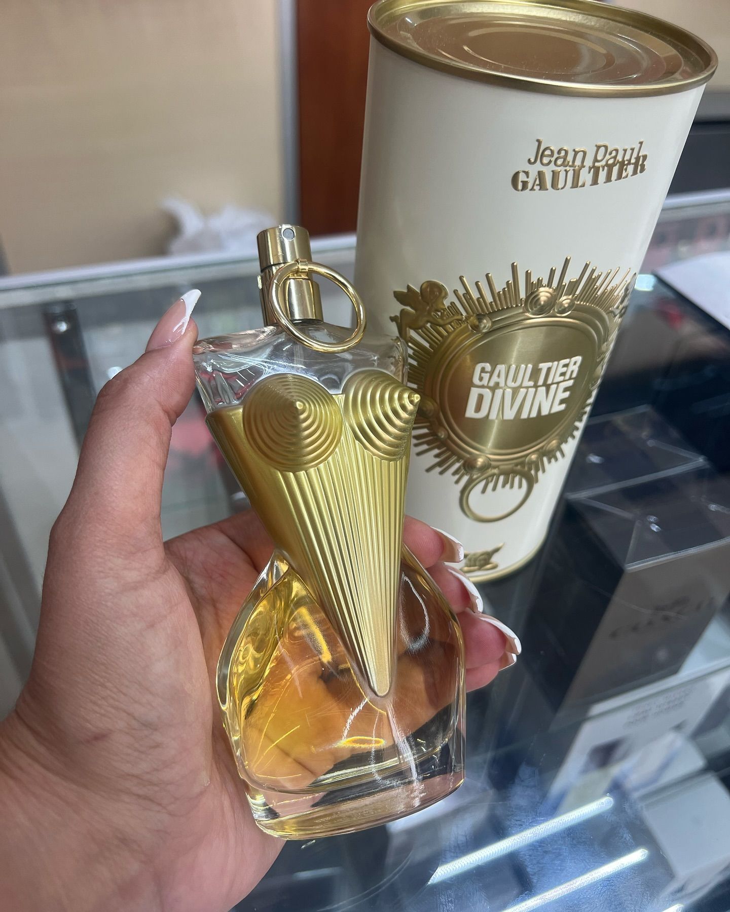 A person is holding a bottle of perfume in their hand.