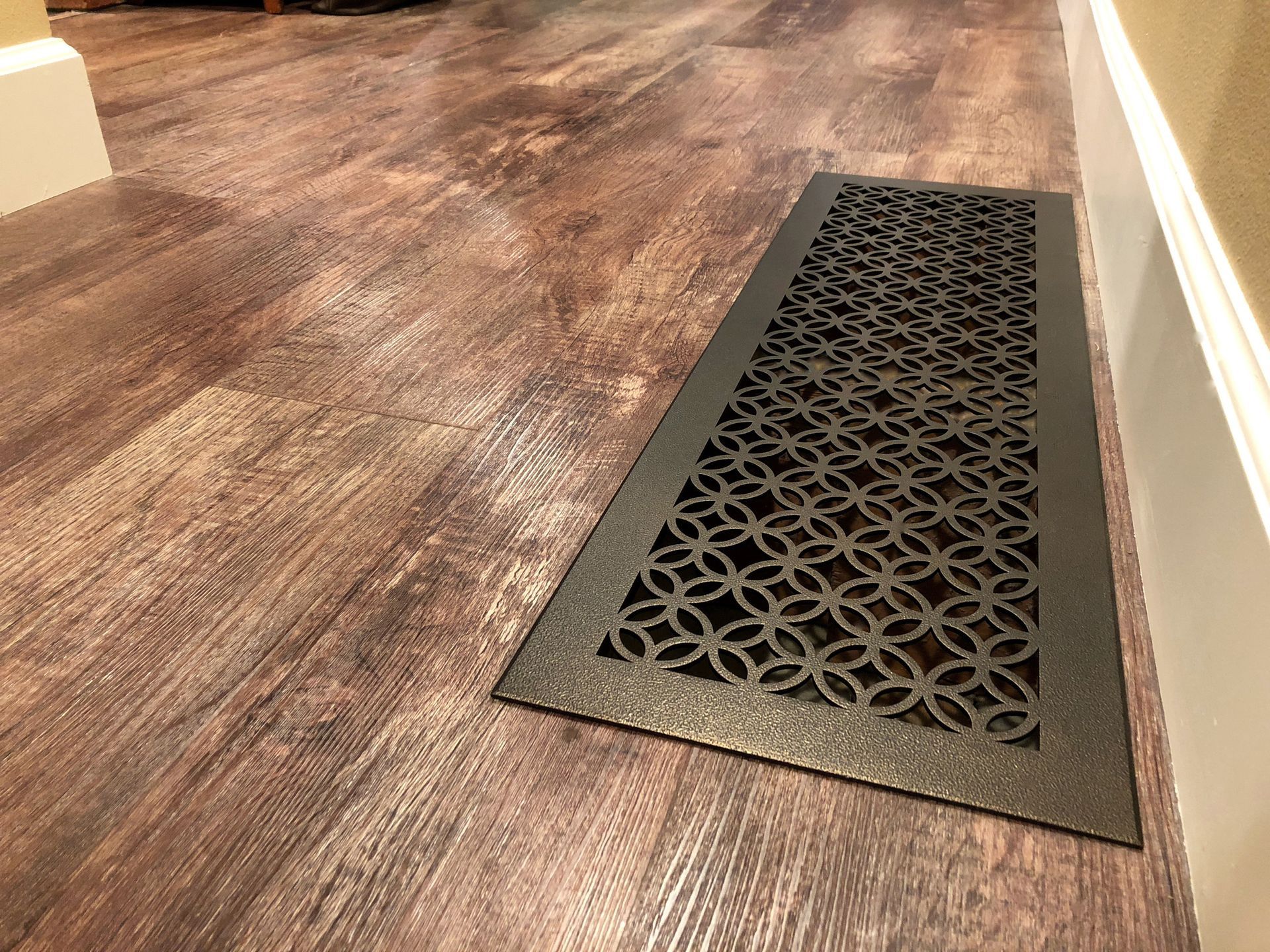 A wooden floor with a black mat on it.