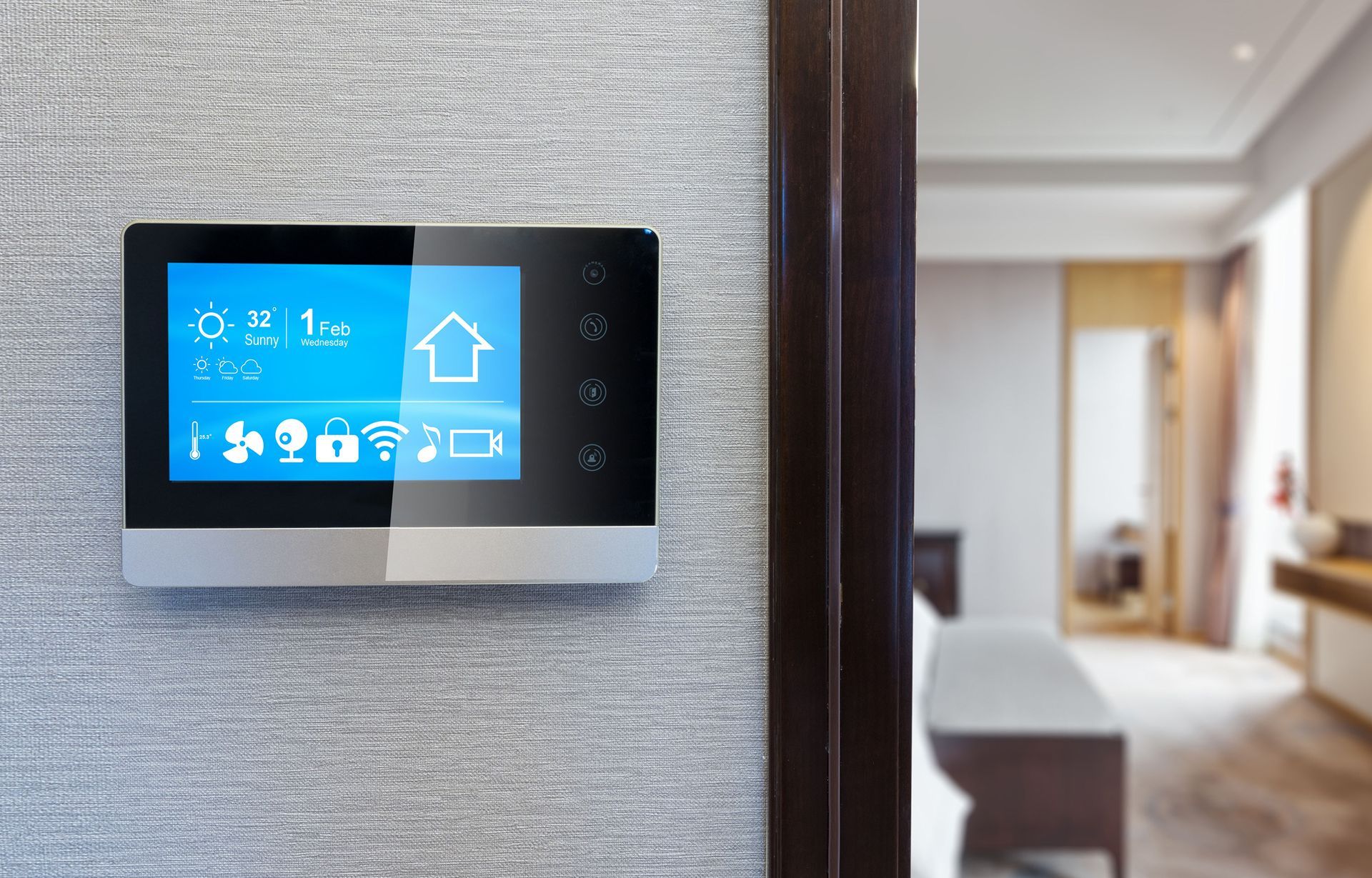 A smart thermostat is hanging on a wall next to a door in a bedroom.