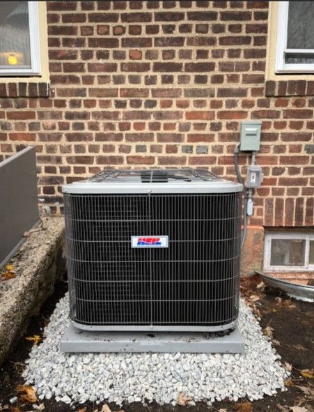 An air conditioner is sitting outside of a brick building