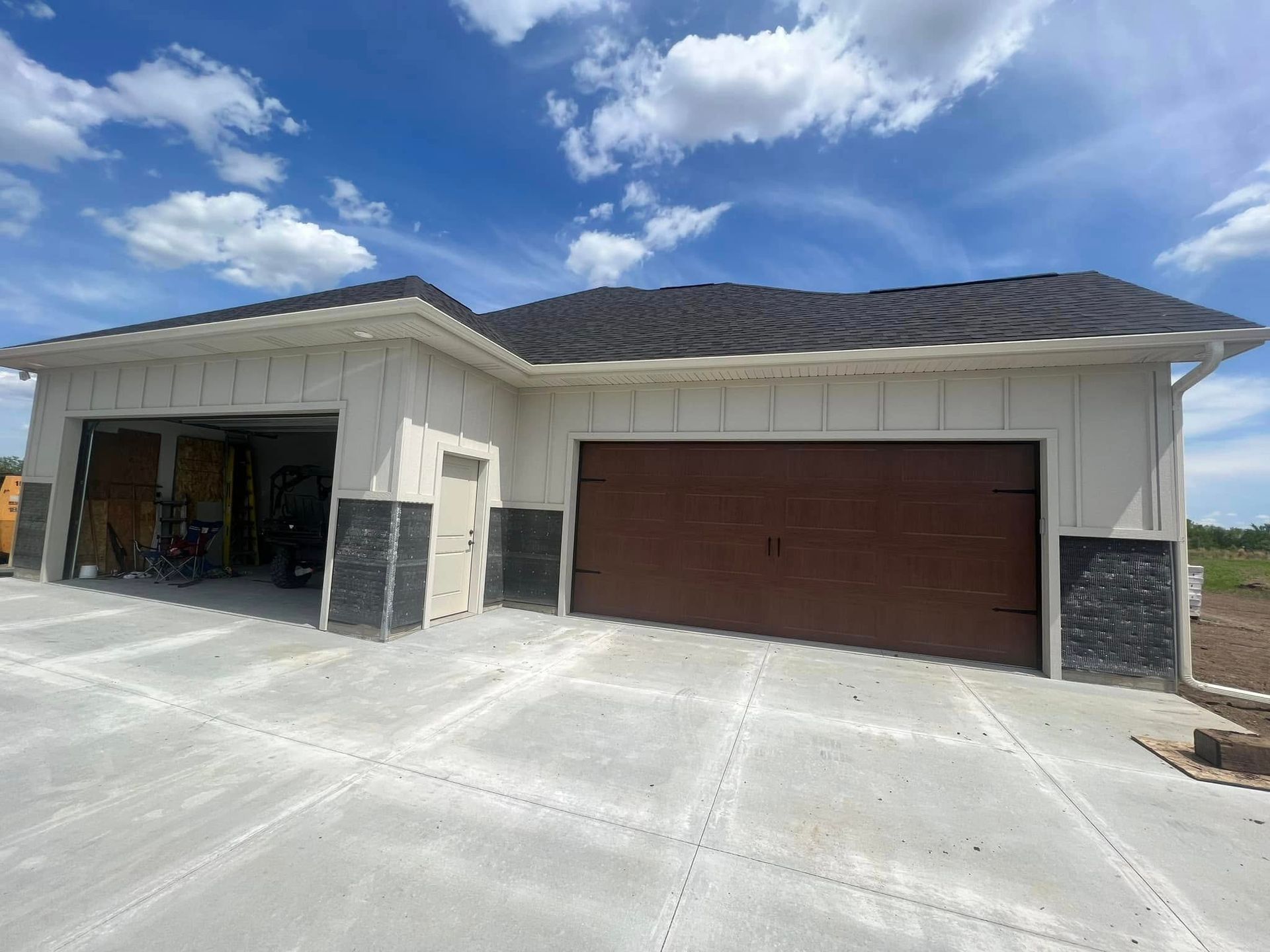 Single-story beige house with a dark brown garage door and white trim under a blue sky