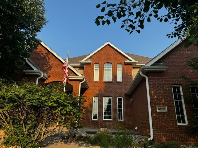 Perforated metal roof edge and gutter beside asphalt shingles, close-up view