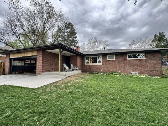 Suburban house with a two-car garage, driveway, and blue sky overhead