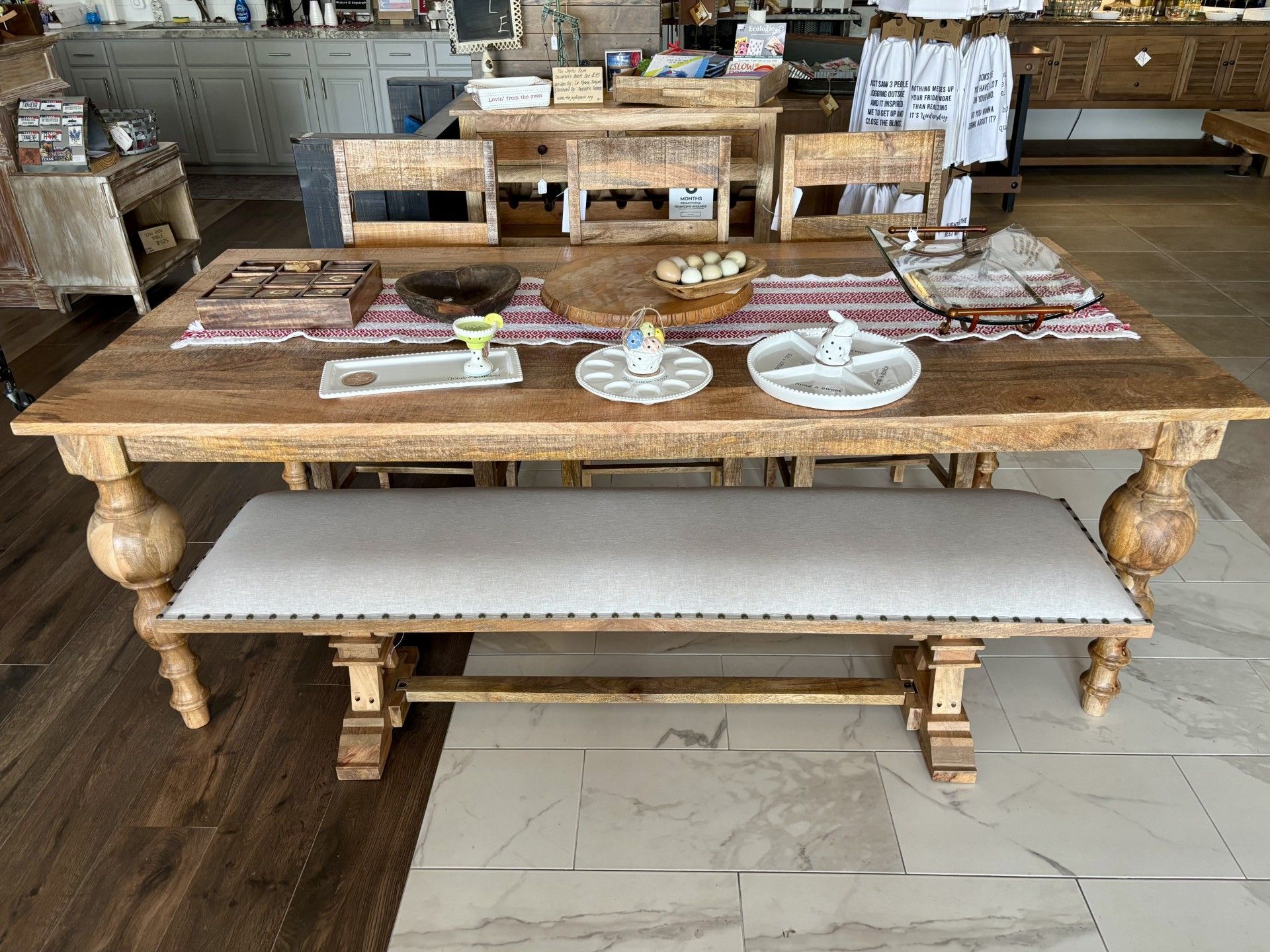 A wooden dining table with a bench and chairs in a room.