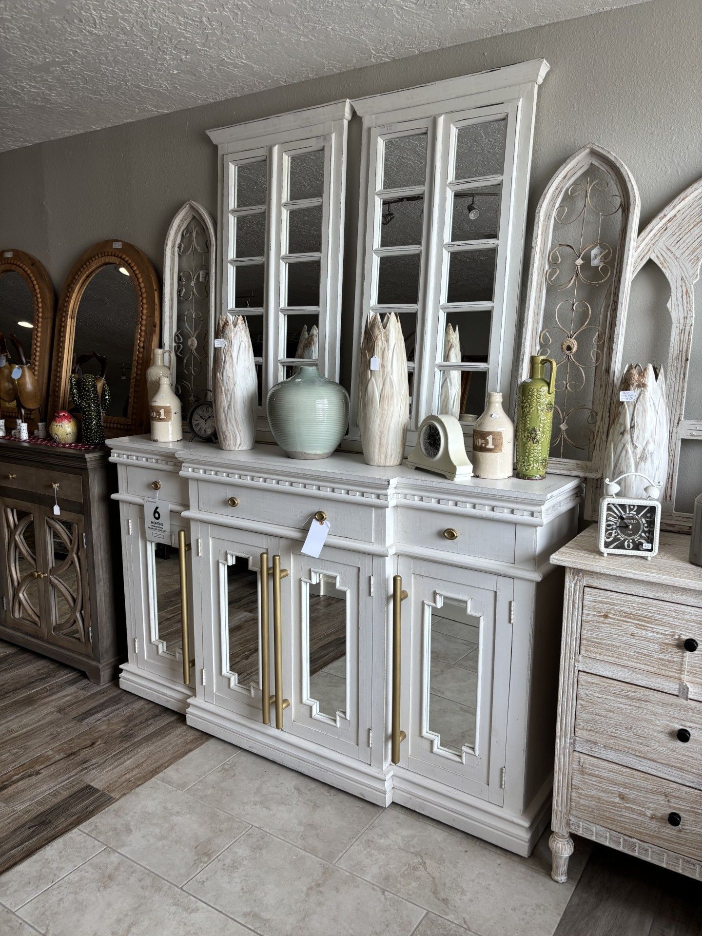 A living room with a blue and white cabinet and a mirror.