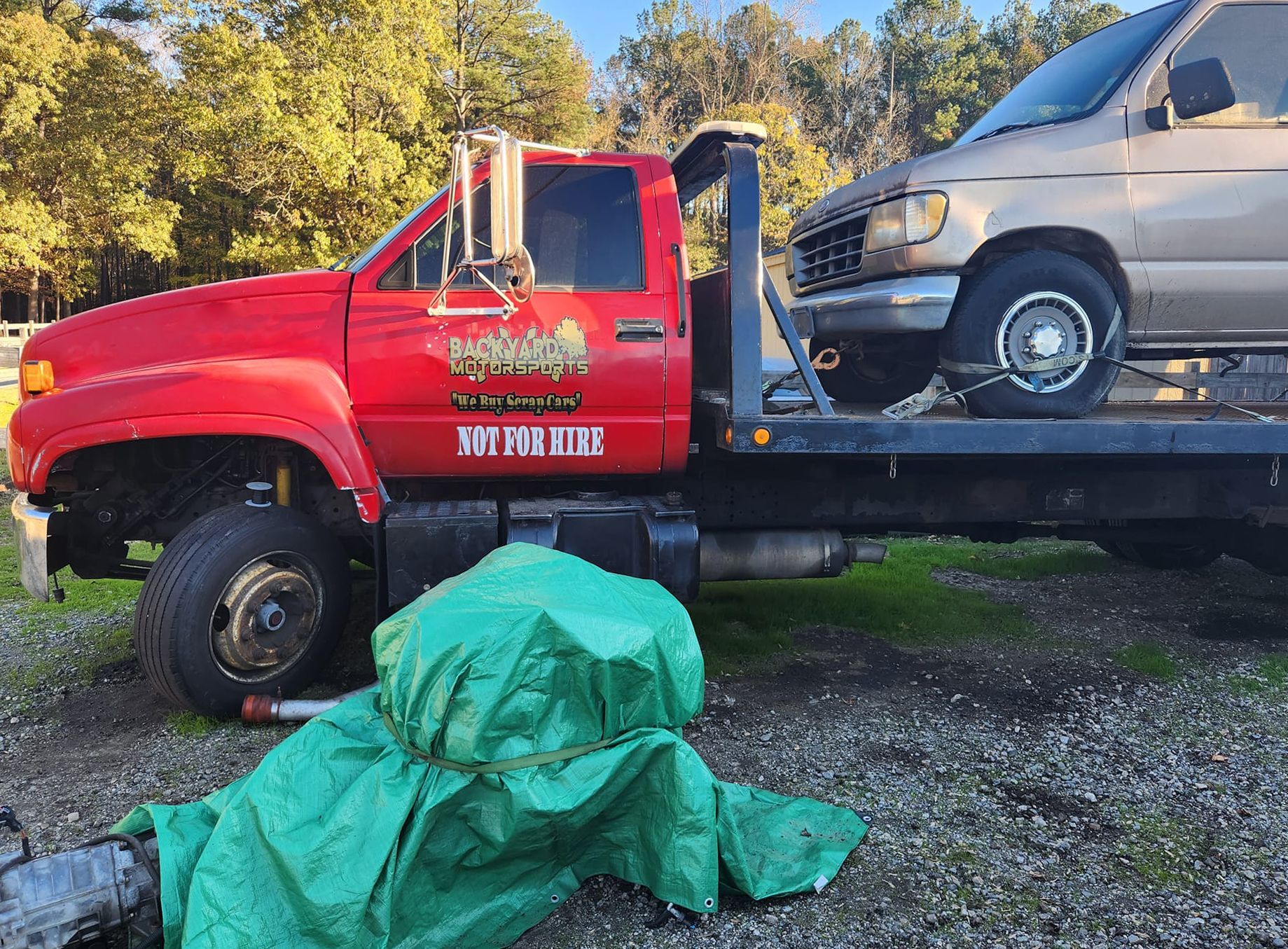 A tow truck with a car on the back of it
