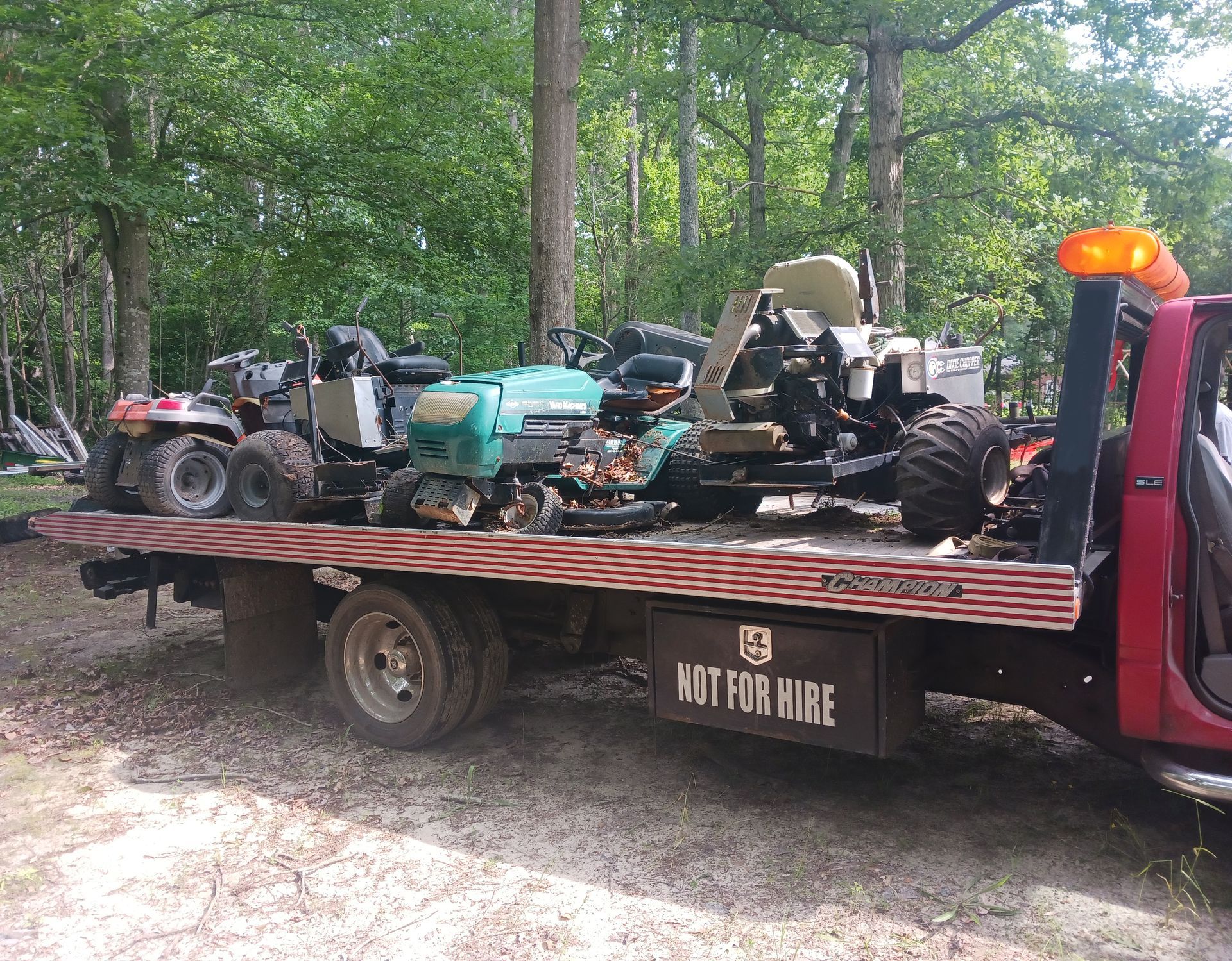A tow truck with lawn mowers on the back of it