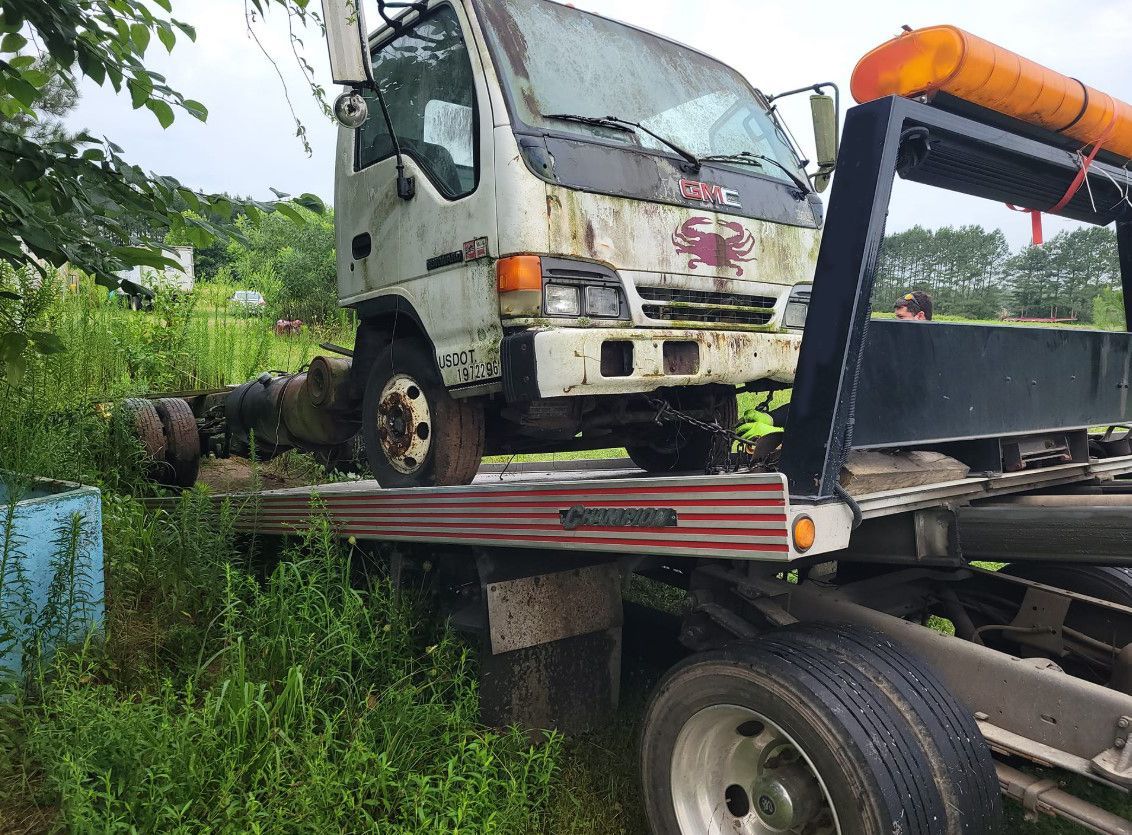 A white truck is sitting on top of a tow truck.